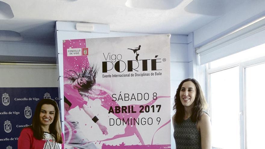 La edil Laura Iglesias (d) y Lorena López, delante del cartel. // FdV