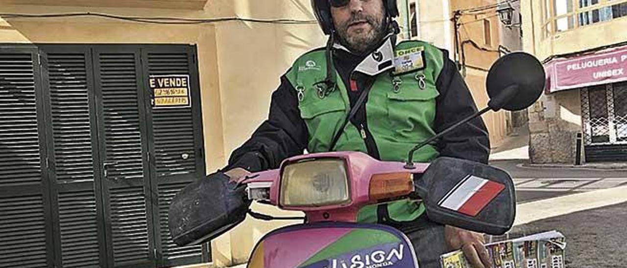 Carlos Méndez, con el ciclomotor con el que reparte cupones a domicilio.