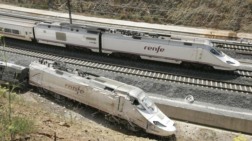 Un Alvia pasa junto a los restos del tren siniestrado