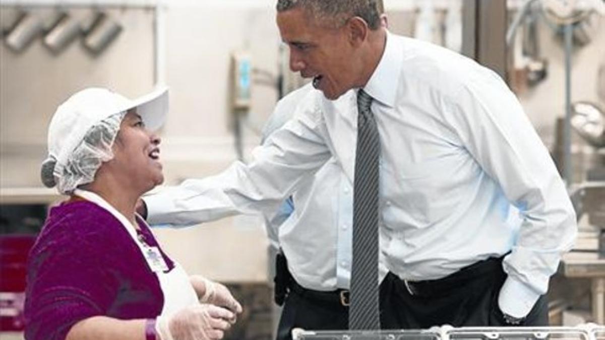 Barack Obama saluda a una trabajadora del sector de la alimentación durante su viaje a Maryland, ayer.