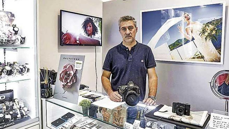 Ignasi GarcÃ­a, con una de las cÃ¡maras de fotografiar daÃ±adas por la riada, en su tienda.