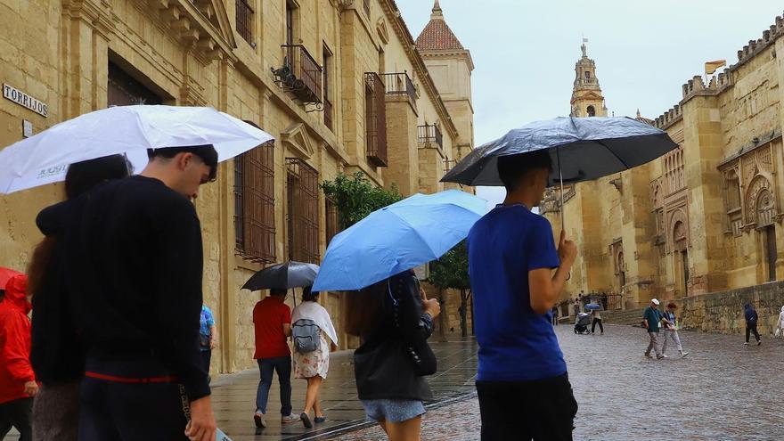 Varios jóvenes con paraguas junto a la Mezquita-Catedral, en una imagen de archivo.