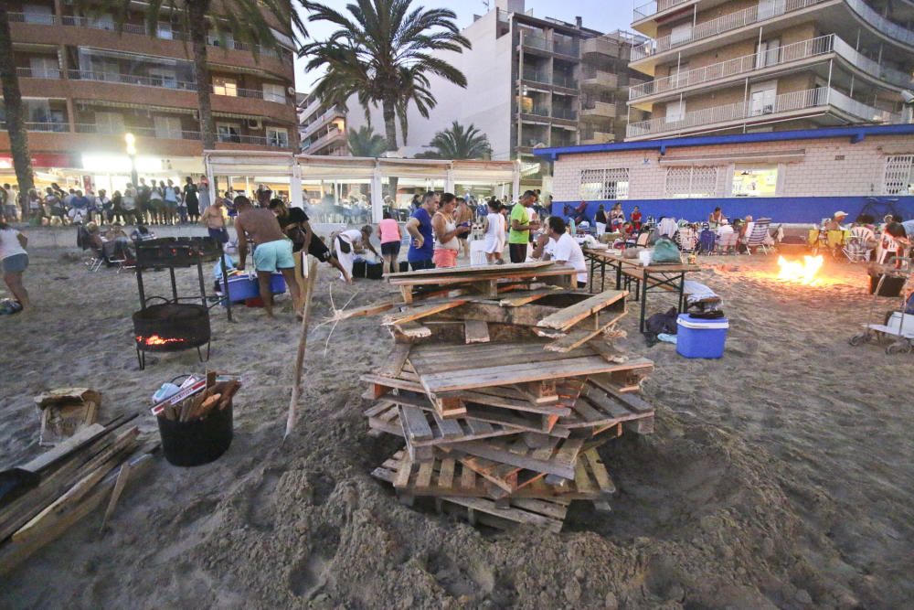 Noche de hogueras, baños, en las playas de la Vega Baja. En las imágenes grupos de amigos y familias en la playa del Cura de Torrevieja