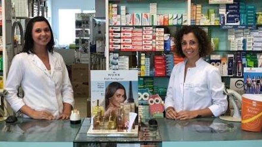 Benita Cardona e Isabel González posan junto el mostrador de la farmacia José Torres Ribas.