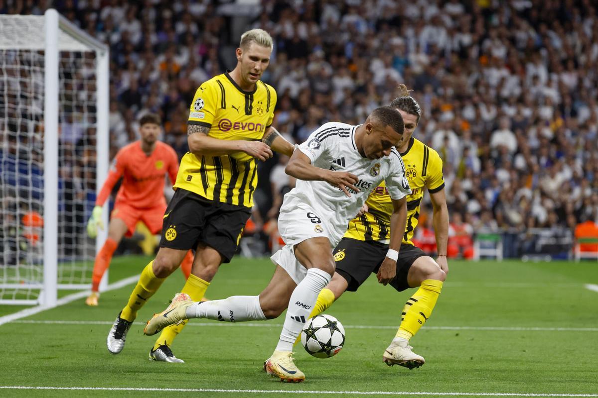 MADRID, 22/10/2024.- El delantero francés del Real Madrid Kylian Mbappé (c) disputa un balón con Marcel Sabitzer (d) y Niklas Süle (i), del Borussia, durante el encuentro correspondiente a la fase regular de la Liga de Campeones entre Real Madrid y Borussia Dortmund, este martes en el estadio Santiago Bernabéu, en Madrid. EFE/Juanjo Martín