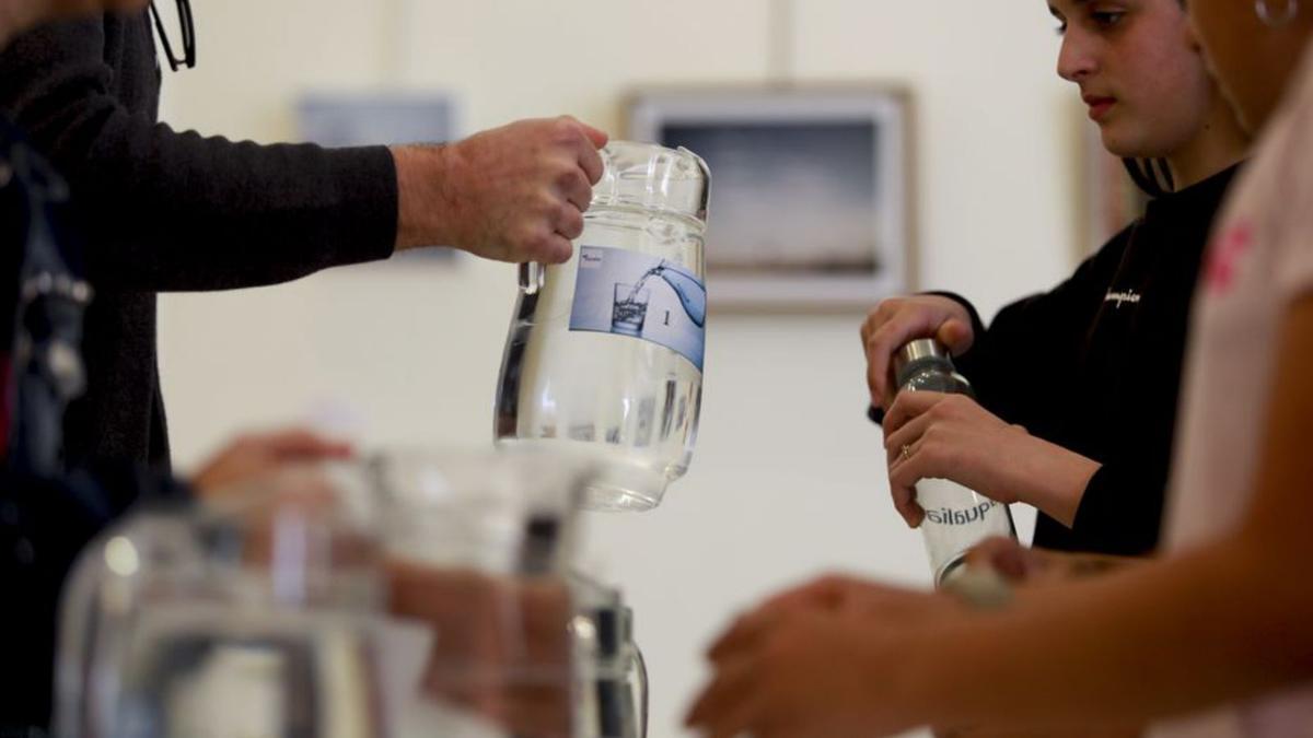 Los niños prueban un poco de agua de cada jarra. | TONI ESCOBAR