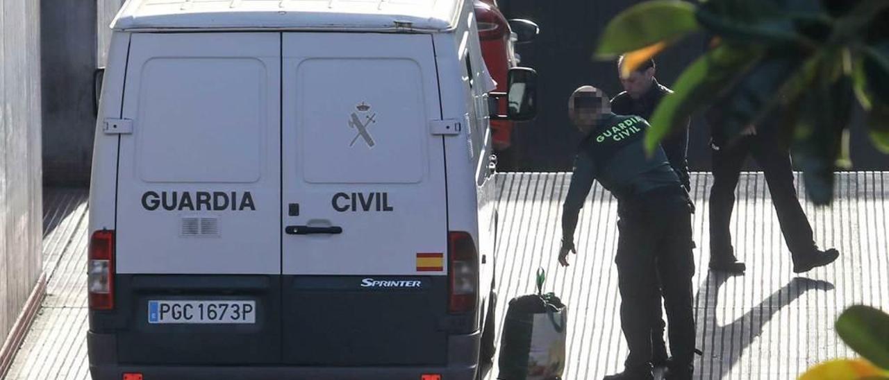 Un agente de la Guardia Civil ayuda a José Manuel Sánchez a recoger la bolsa con sus pertenencias antes de subir al furgón que le trasladó al Centro Penitenciario de Asturias el viernes.