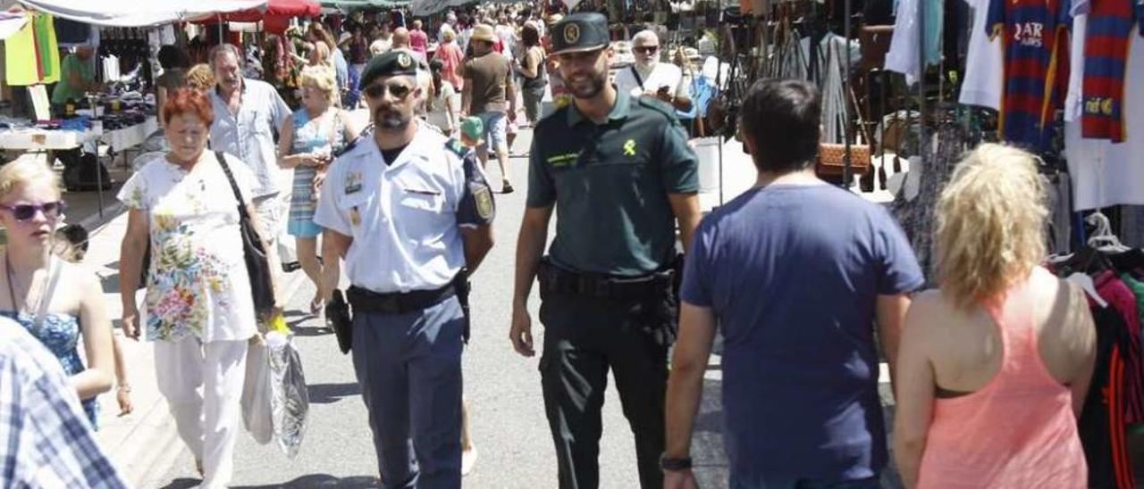 Los agentes Rui Correia (GNR) y Miguel de Anta (Guardia Civil), ayer en el mercadillo de Sabarís. // R. Grobas