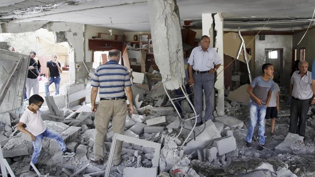 Palestinos inspeccionan una de las casas familiares demolidas por el Ejército israelí, en Jerusalén este, este martes.