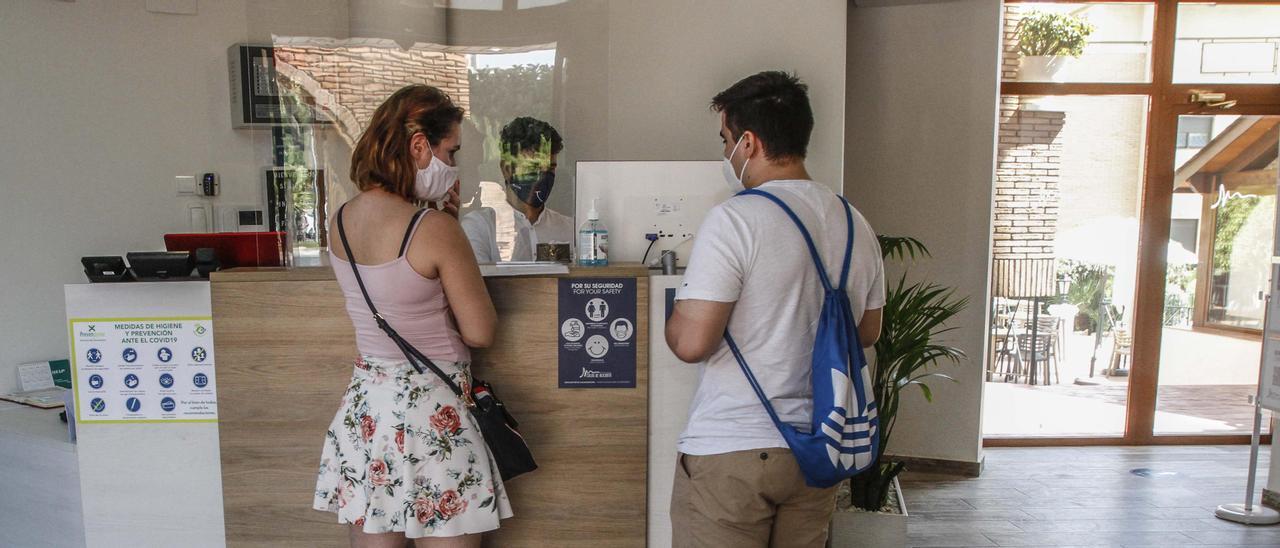 Una pareja de turistas registrándose en un hotel de Alicante