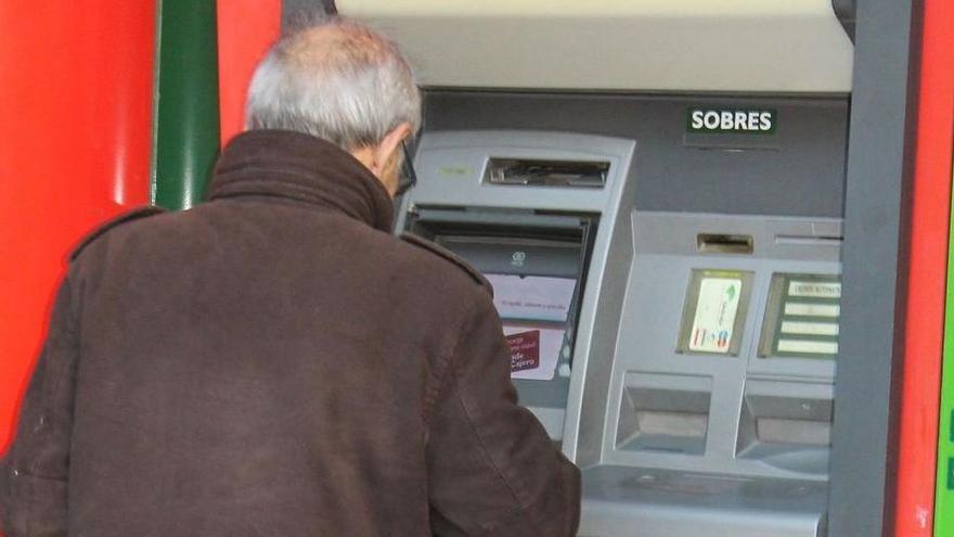 Un cliente saca dinero de un cajero automático.