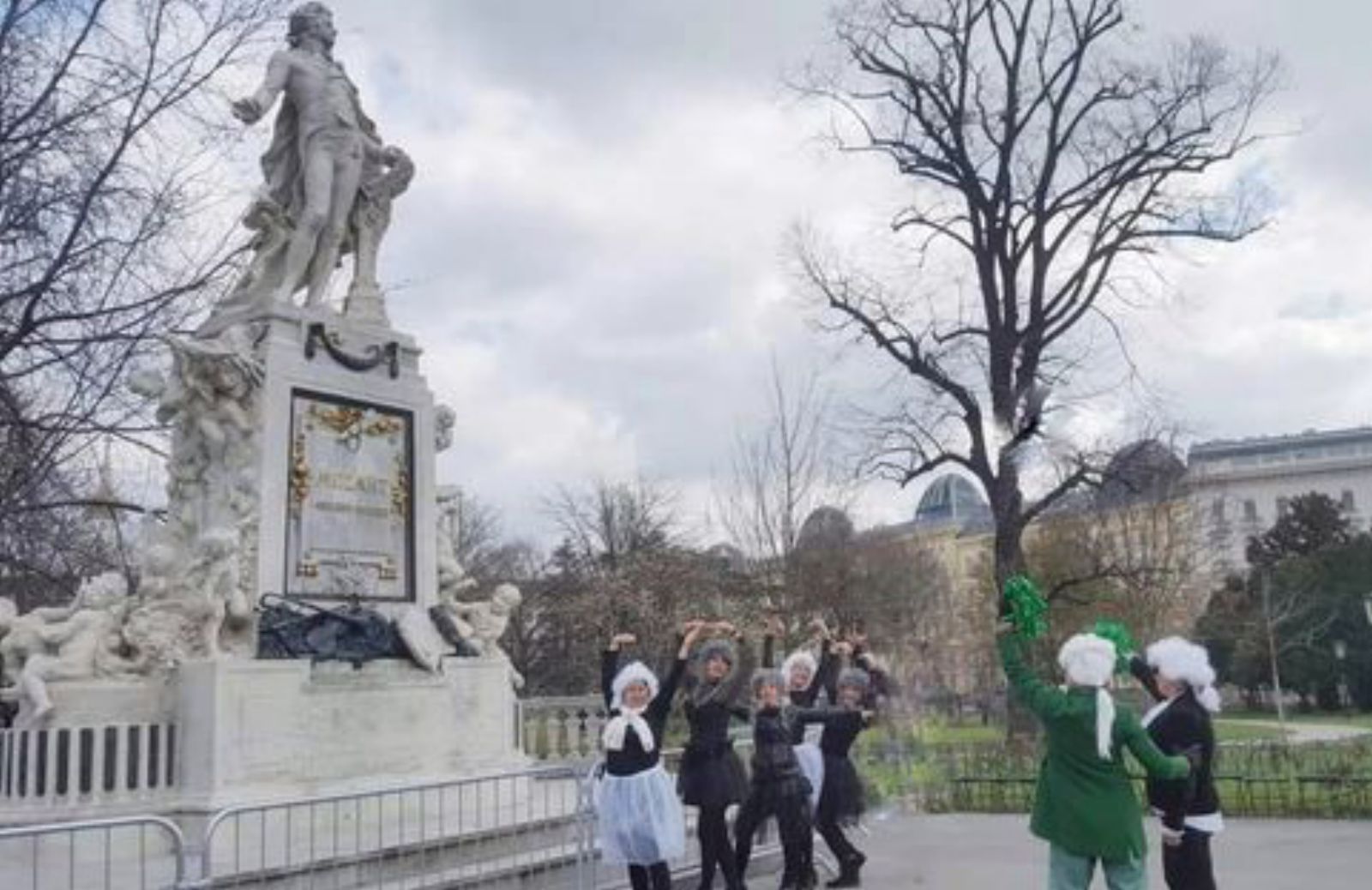 El grupo, vestidas de Mozart, ante su estatua, en Viena.