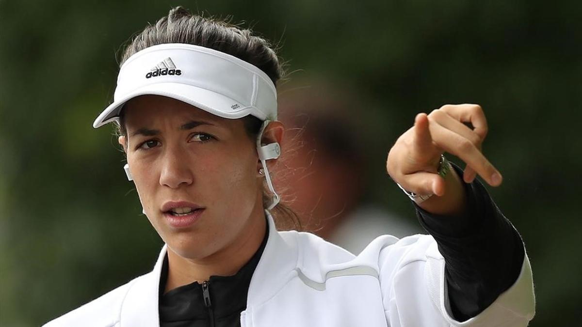 Garbiñe Muguruza se dirige al entrenamiento de este viernes, escuchando música en sus auriculares.