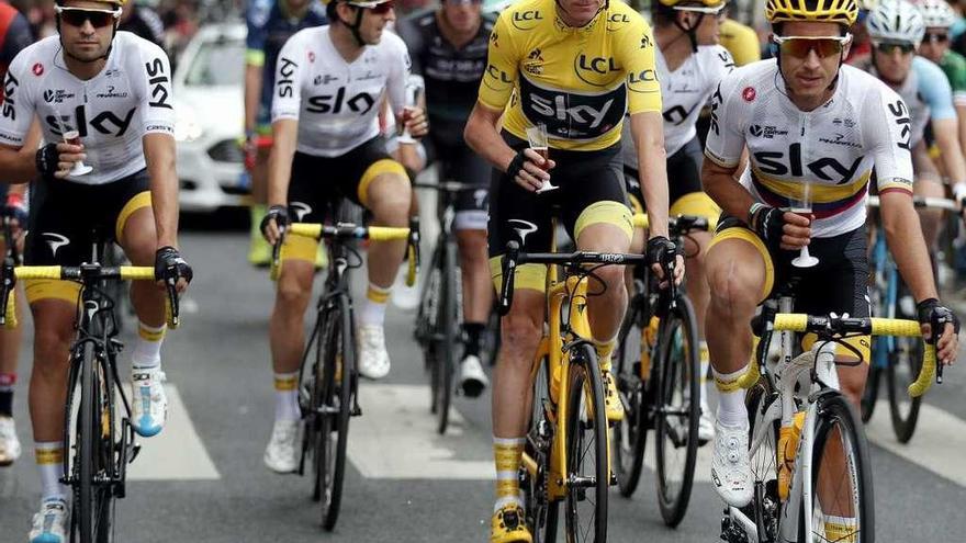 Arriba, Froome festeja con sus compañeros del Sky su victoria en la pasada edición del Tour. // B. Tessier