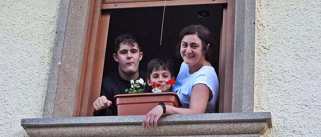 Una familia se asoma por la ventana en Vilariño de Conso.   | // FERNANDO CASANOVA