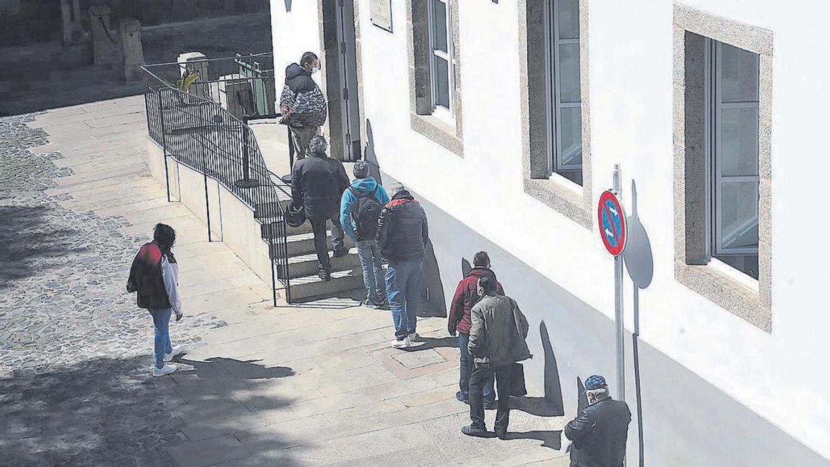 Un grupo de ciudadanos espera para comer en la Cocina Económica de Santiago.