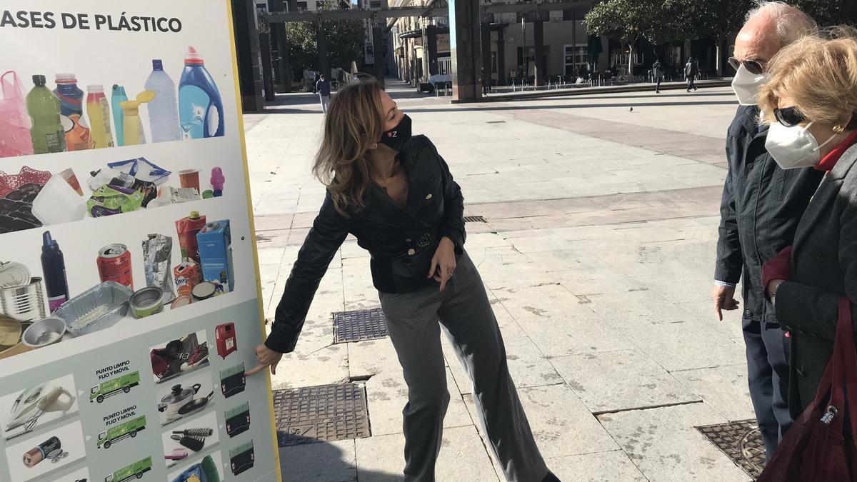 La consejera de Servicios Públicos y Movilidad del Ayuntamiento de Zaragoza, Natalia Chueca, enseña los totems de reciclado a unos viandantes