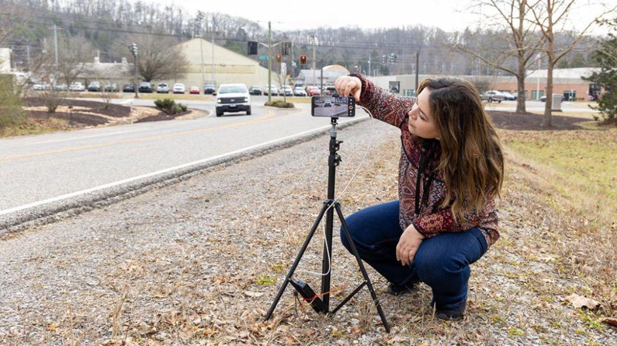 La investigadora Sally Ghanem instala una cámara para capturar los números de matrícula de los vehículos que pasan en una ruta determinada.