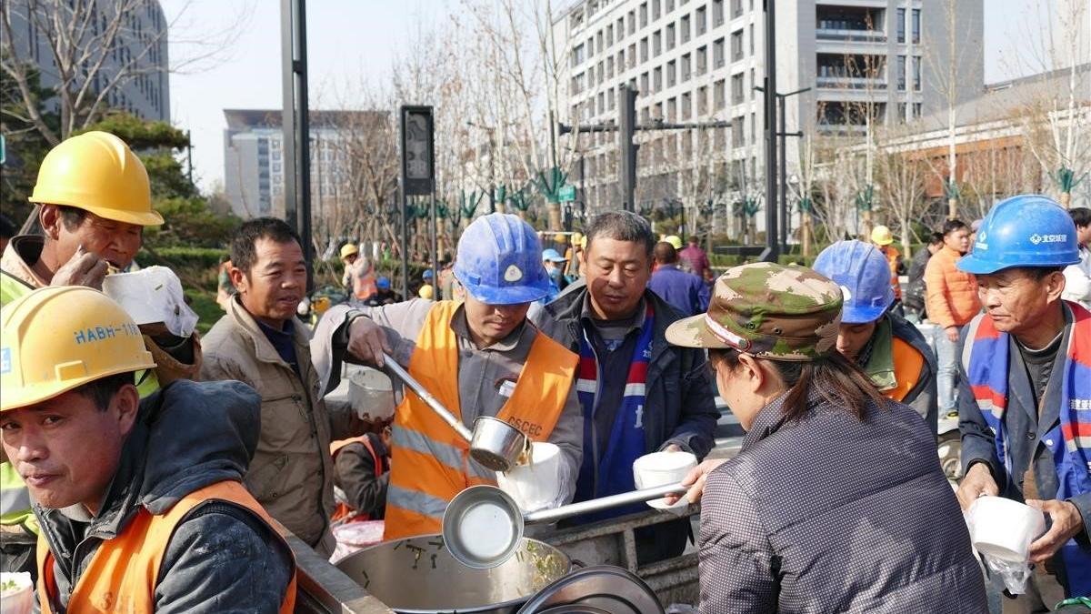Un grupo de obreros almuerza en la ciudad china de Tongzhou.