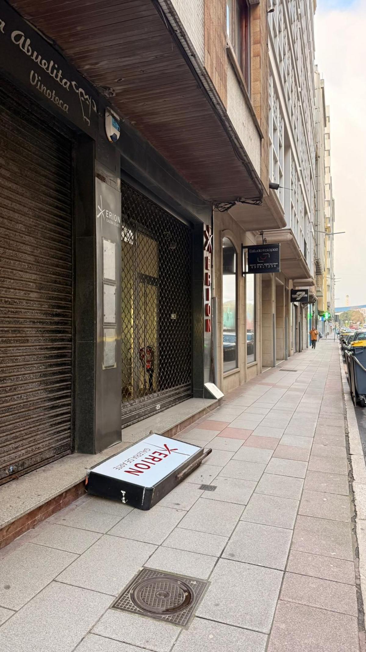 Cartel de la galería de arte Xerión caído por el viento