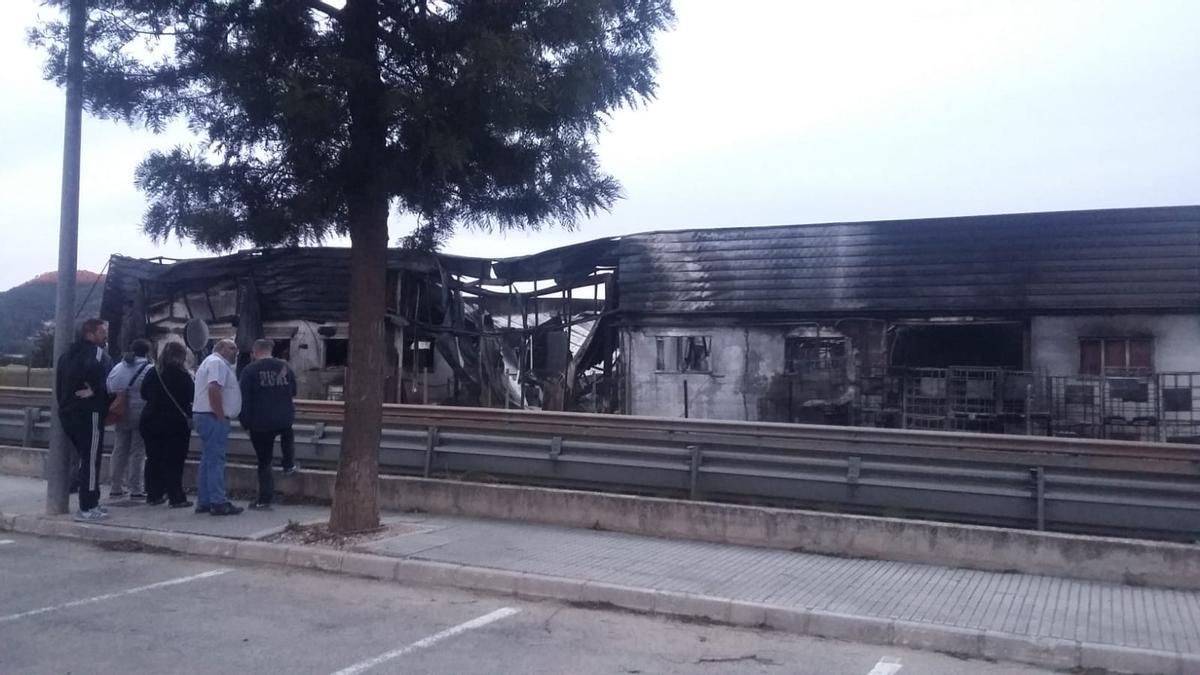 Vecinos y trabajadores de la empresa observan los daños causados en la nave siniestrada.