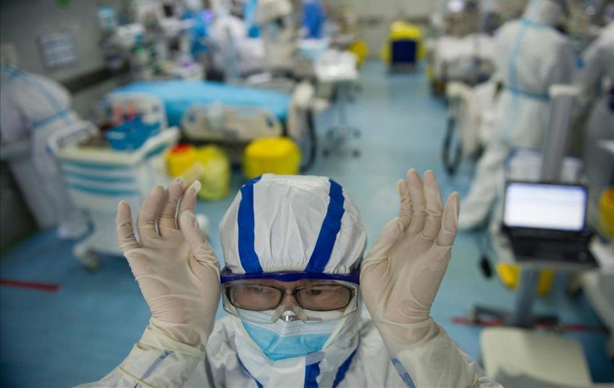 Una infermera se ajusta las gafas antes de empezar a trabajar con pacientes del coronavirus en un hospital en Wuhan, China.