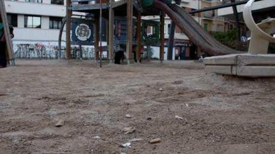 Colillas y otros restos de suciedad esparcidos en un parque infantil.