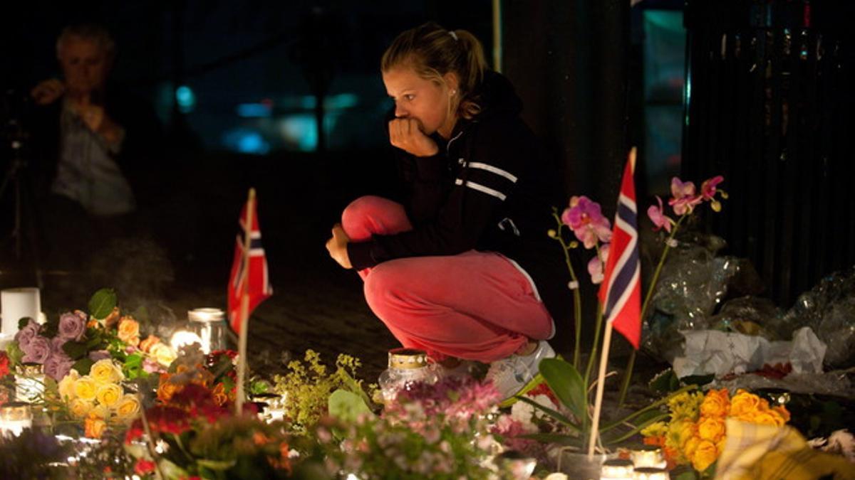 Una mujer homenajea a los muertos en las masacres de Noruega ante la iglesia de Domkirke en Oslo.