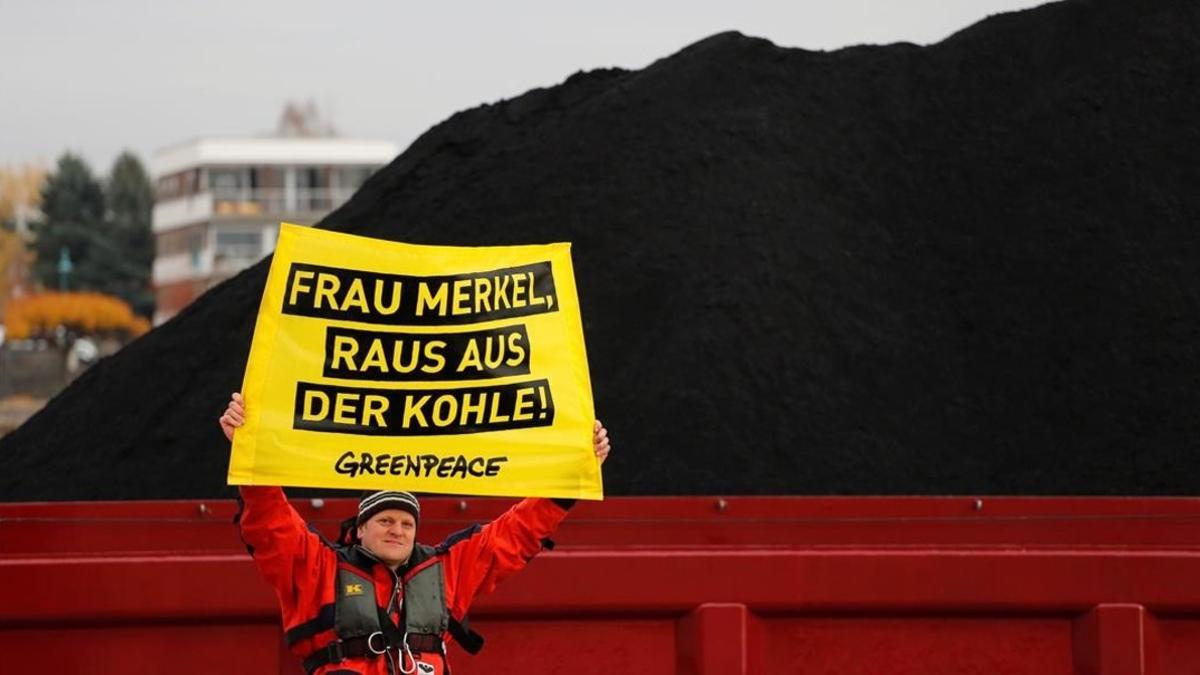 amadridejos40954868 an activist holds up a banner reading  merkel  get out of th171116220823