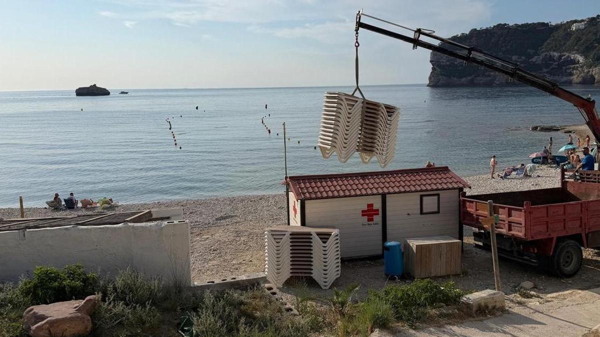 El camión pluma descarga las hamacas este jueves de buena mañana en la cala de la Barraca