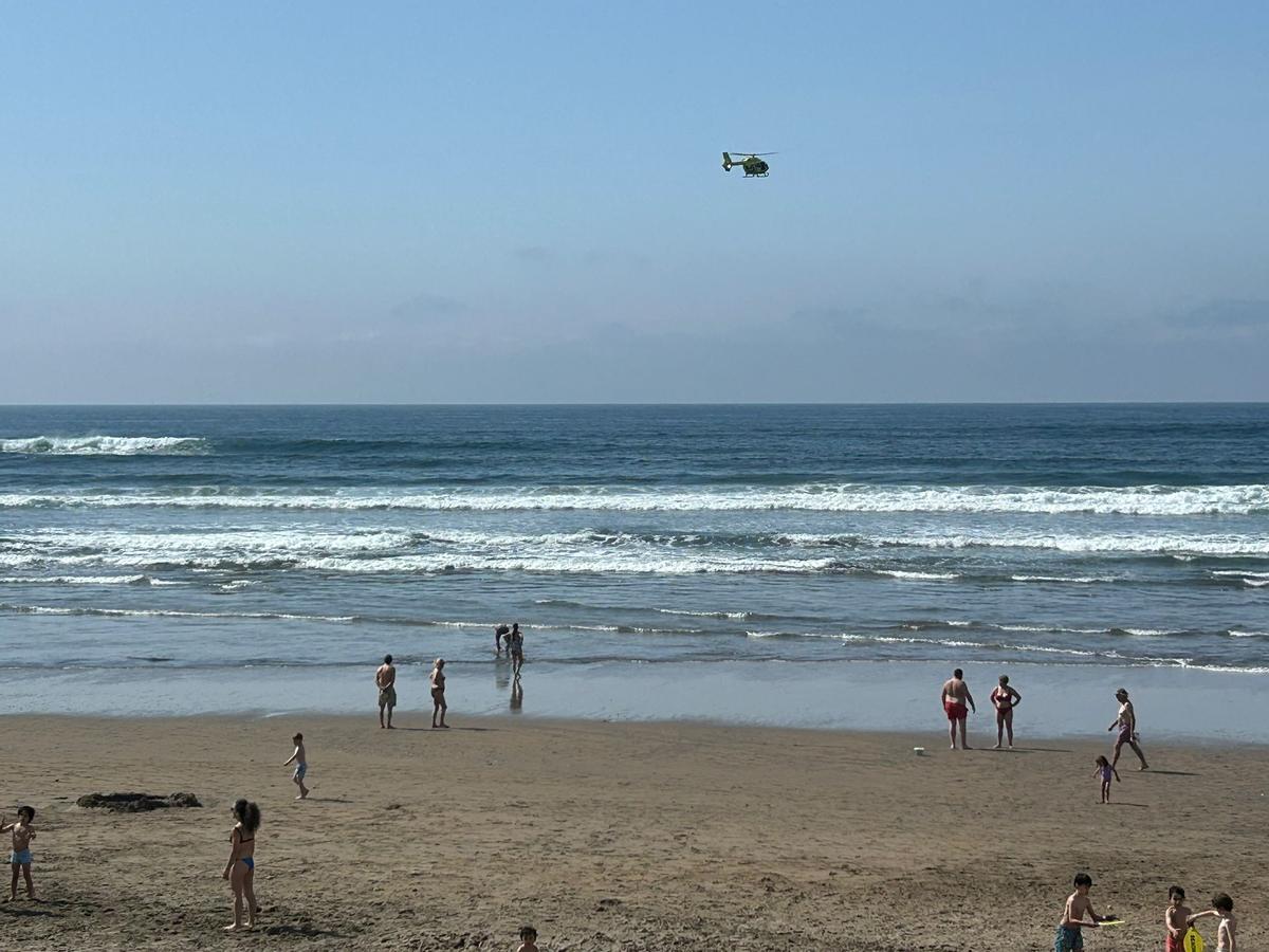 Un helicóptero sobrevuela la bahía de Salians ante la mirada de bañistas.