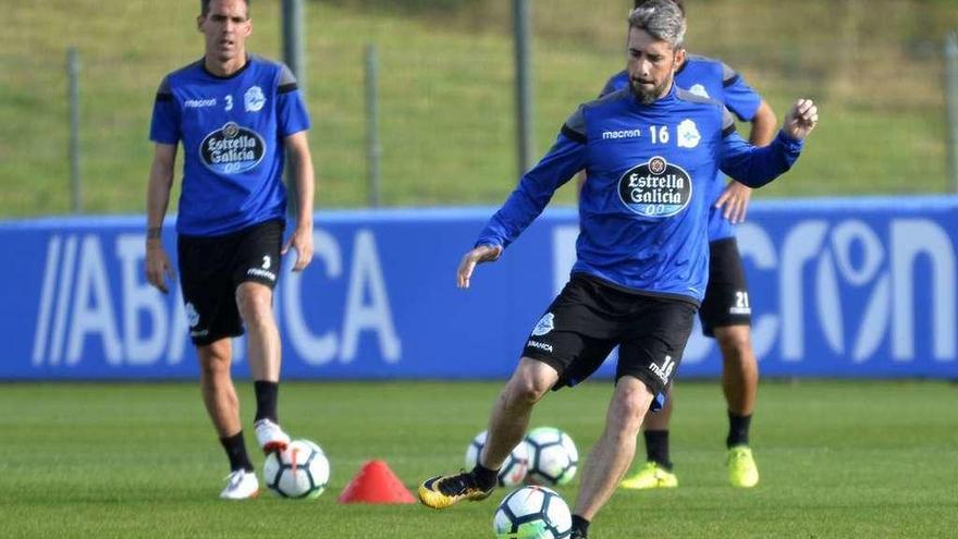 Luisinho golpea el balón durante un entrenamiento en presencia de Navarro.