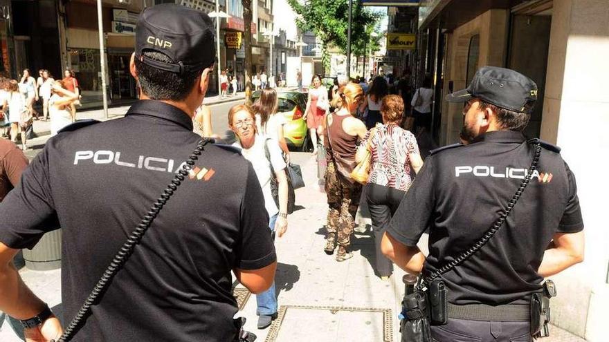 Dos policías nacionales, patrullando en una céntrica calle de Pontevedra. // Rafa Vázquez