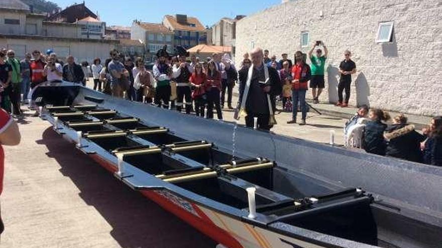 El sacerdote Eduardo Mallo bendice el bote. // G.Núñez