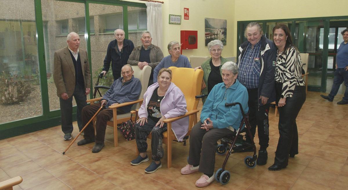 Un grupo de personas mayores del centro de Cornuval, junto a la directora.