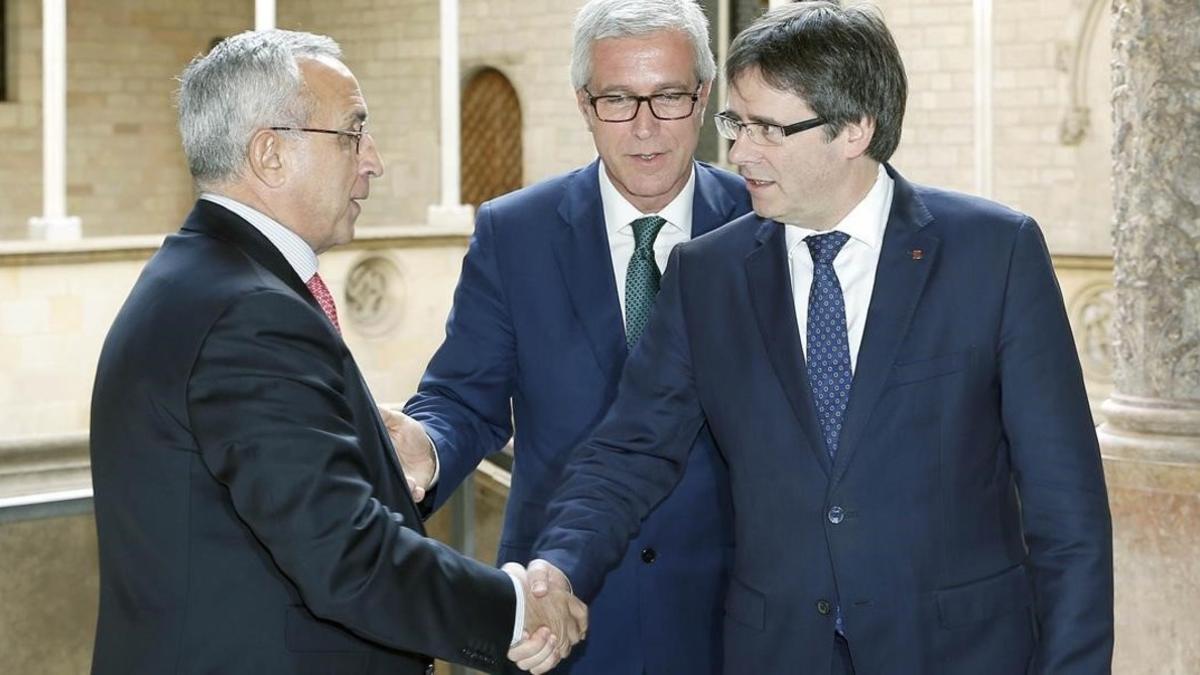 El presidente del COE, Alejandro Blanco, saluda al presidente de la Generalitat, Carles Puigdemont, en presencia del alcalde de Tarragona, Josep Fèlix Ballesteros, durante la reunión de este lunes sobre los Juegos Mediterráneos.