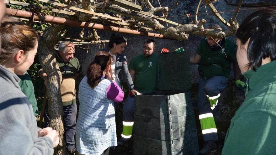 Los alumnos del taller de empleo enseñan a utilizar los composteros, con la presencia de la alcaldesa, Nidia Arévalo. / FdV