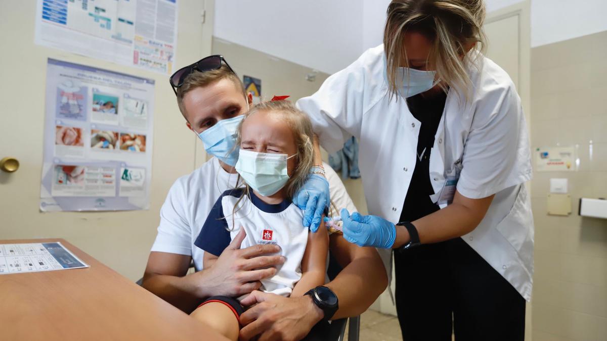 Valeria, de 4 años, recibe la vacuna frente a la gripe en el centro de salud Fuensanta.