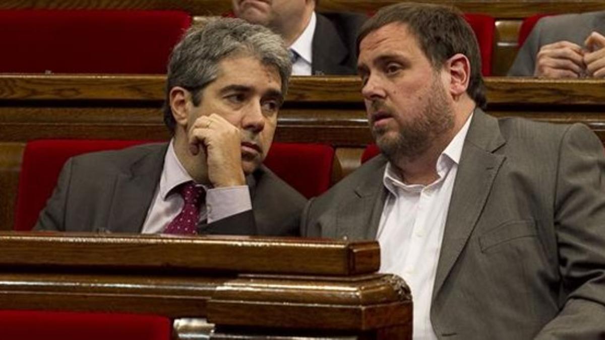 El 'conseller' de Presidència, Francesc Homs, conversa con el líder de ERC, Oriol Junqueras, este miércoles en el Parlament.