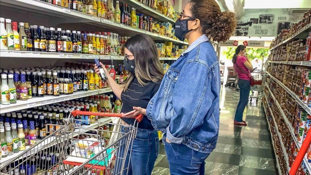 Varias mujeres escogen productos en un pasillo de un supermercado el 15 de octubre de 2020  en Caracas (Venezuela)