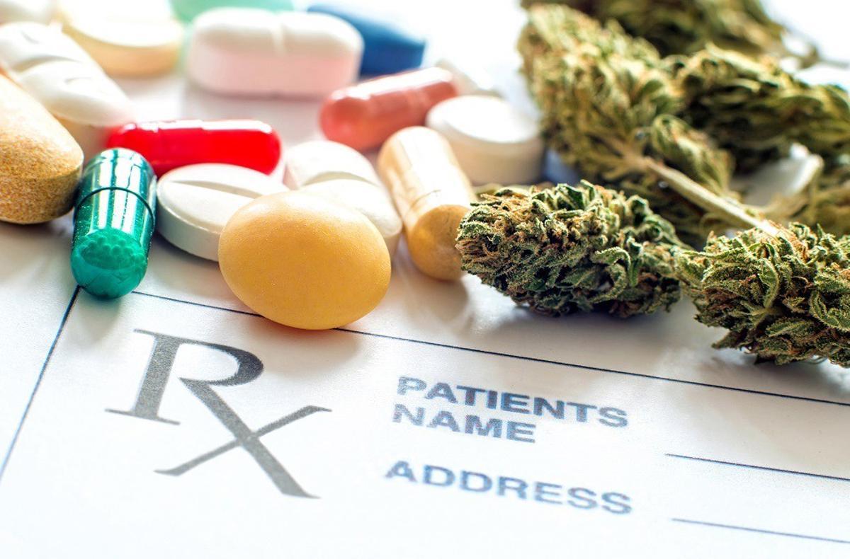 Primer plano de pastillas recetadas frente al cannabis.