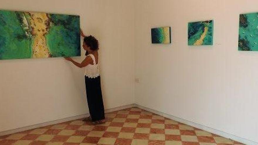 Elena Montesinos junto a algunos de sus cuadros expuestos.
