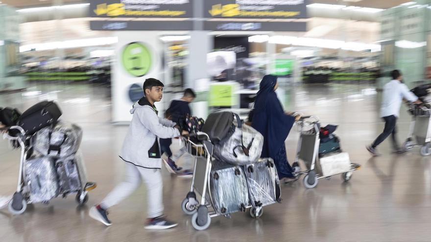 Pasajeros con maletas en un aeropuerto.