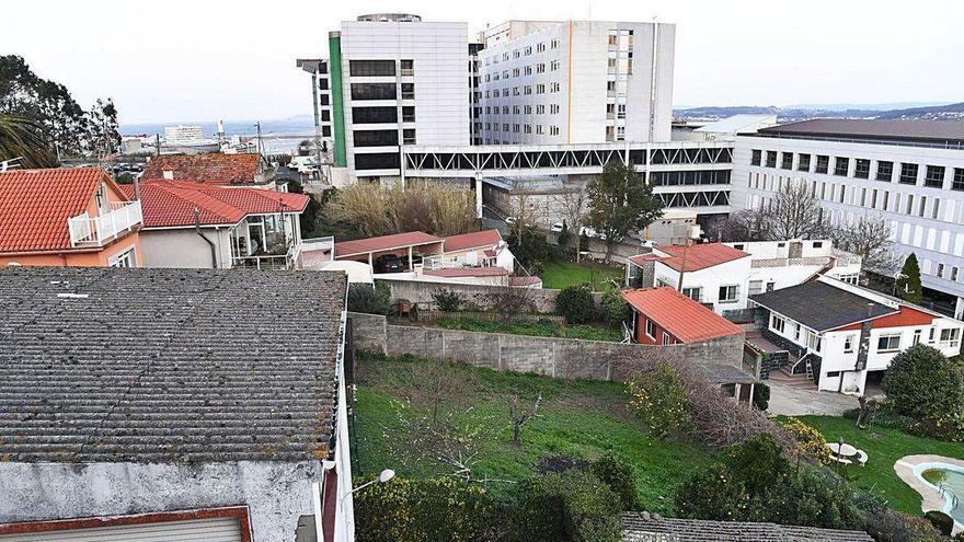 Viviendas de Eirís afectadas por la ampliación, con el hospital al fondo.