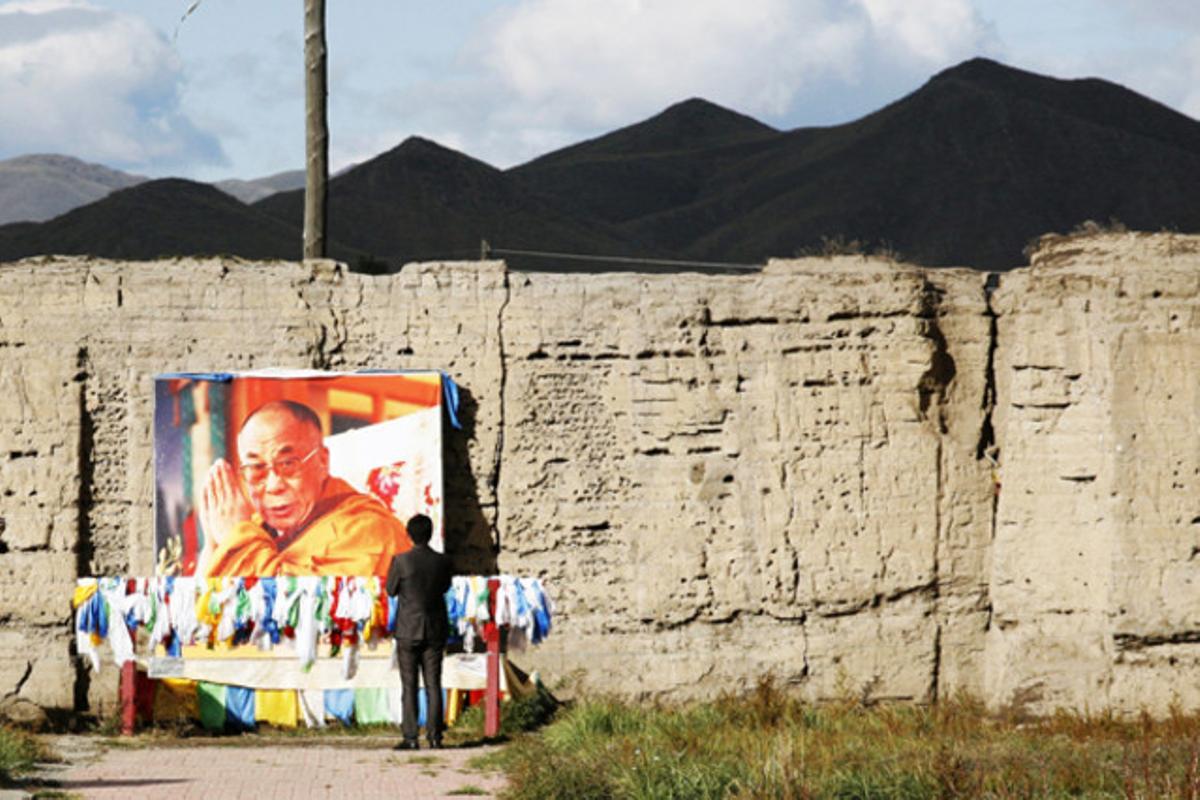 Un home resa davant una imatge del dalai-lama a la regió de Tuva, a Rússia.