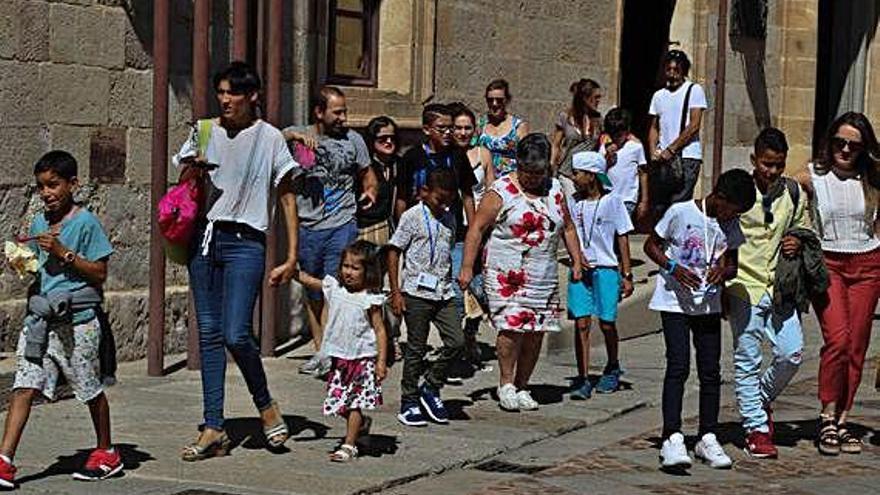 Varios niños y niñas, junto a sus familias de acogida, en la despedida de las últimas Vacaciones en Paz.