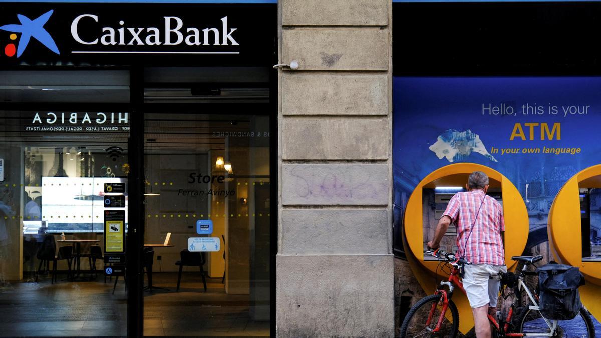 FILE PHOTO: A man uses a Caixabank ATM in Barcelona