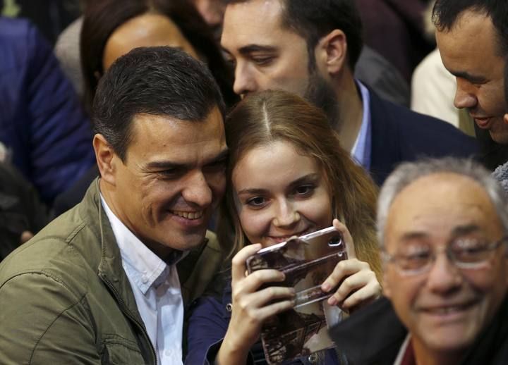 Socialist party (PSOE) leader Pedro Sanchez poses for a selfie with a supporter during a rally to kick off the election campaign for Spain's national election in Getafe, near Madrid