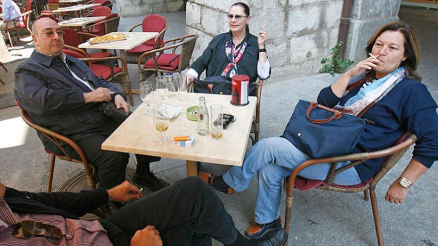 Els clients d&#039;un bar del centre de Girona, aquest divendres, fumant a la terrassa.