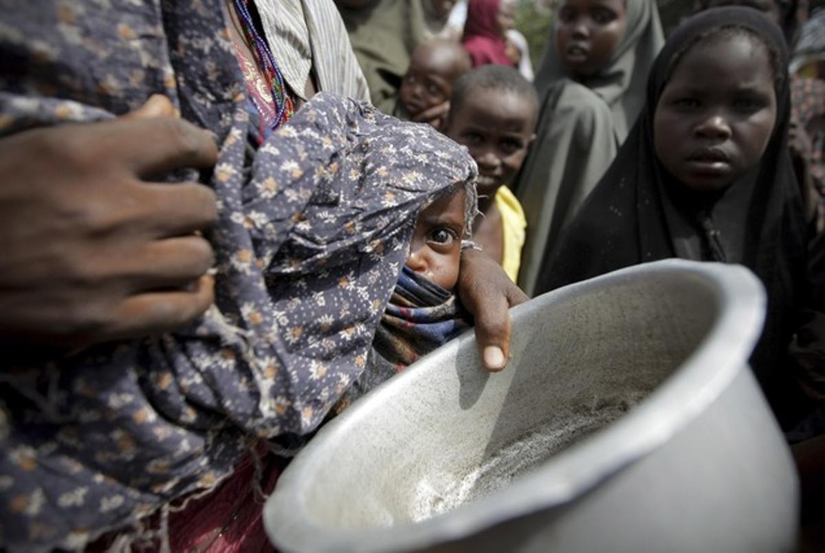 Una dona amb el seu bebè mentre fa cua per aconseguir aliments en un campament per als desplaçats de Mogadiscio (Somàlia). Una dona amb el seu bebè mentre fa cua per aconseguir aliments en un campament per als desplaçats de Mogadiscio (Somàlia).